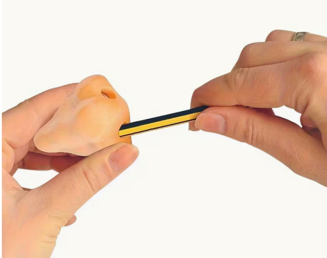 A close-up of a person's hands holding a small rectangular yellow and black object against a plain white background.
