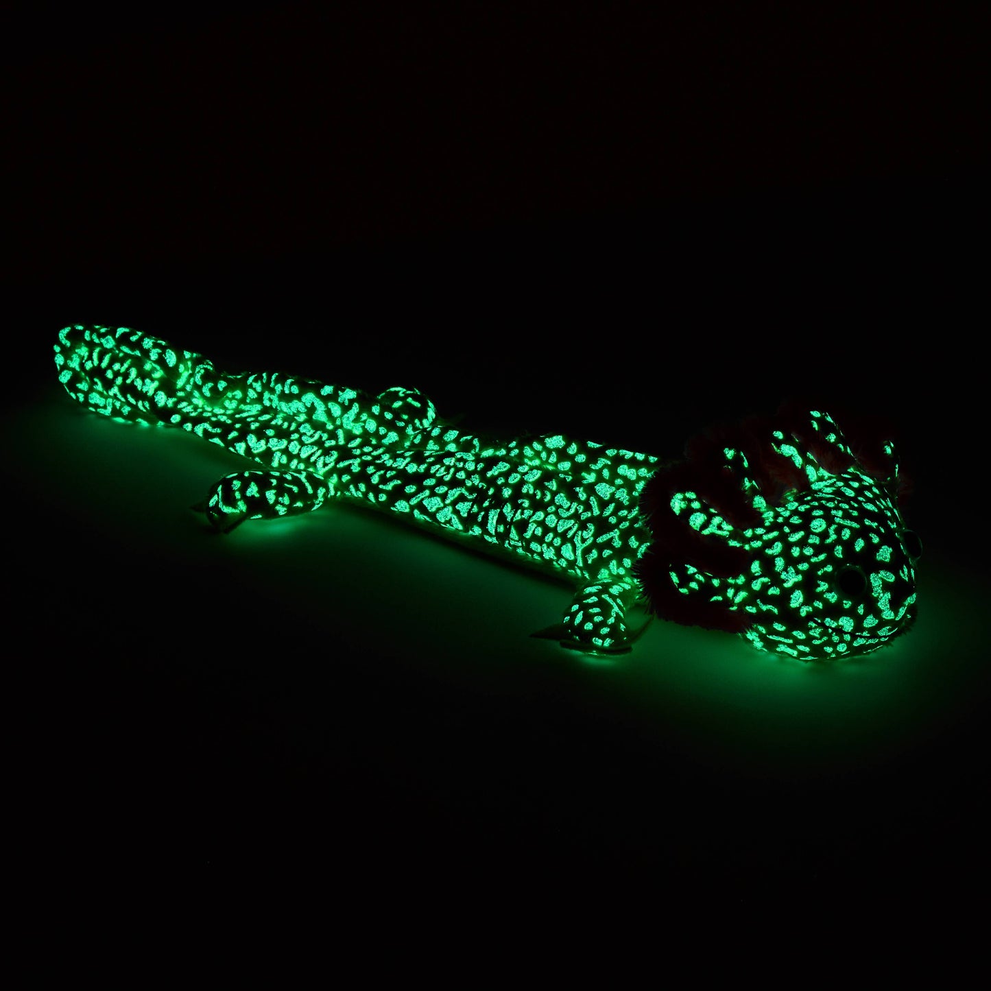 Axolotl stuffed animal glowing bright green in the dark.