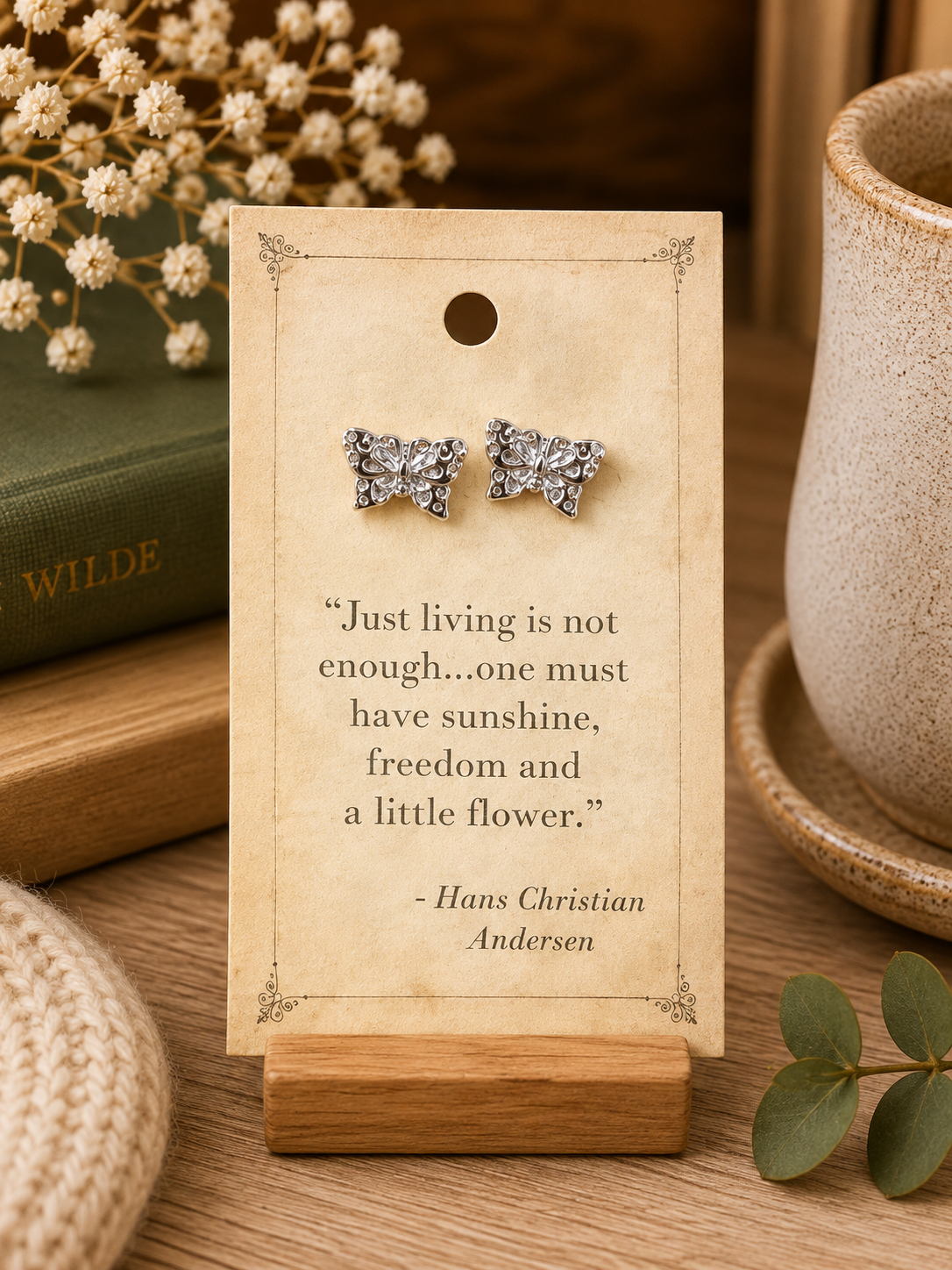 Silver tone butterfly stud earrings displayed on a vintage-inspired Hans Christian Andersen literary quote card