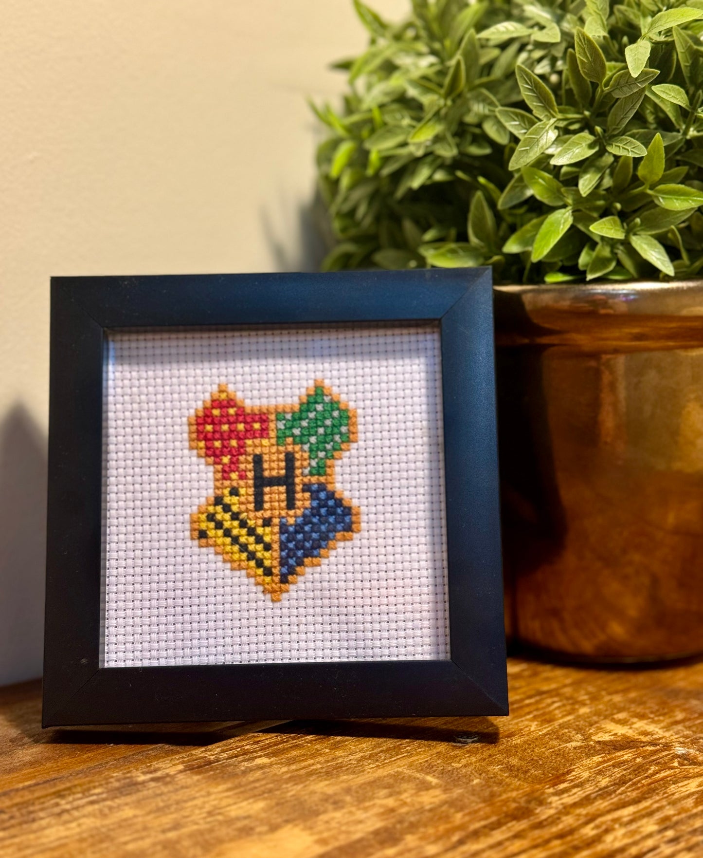 Harry Potter Hogwarts Crest Cross-Stitch Kit featuring a detailed design of the Hogwarts crest with house symbols and vibrant colors.