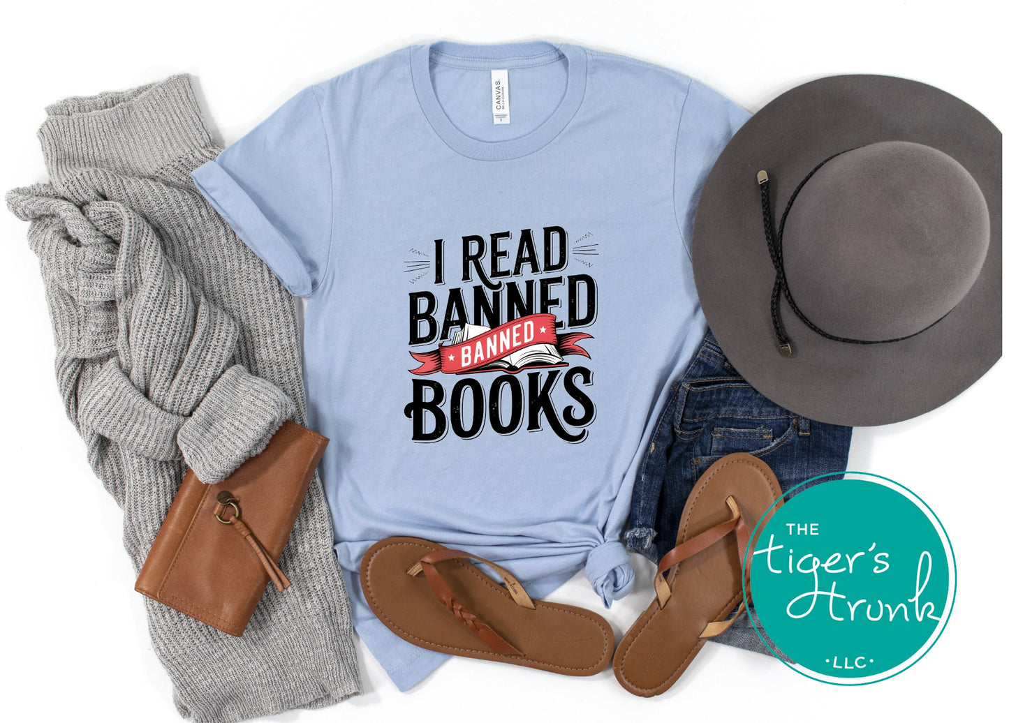 Light blue t-shirt with 'I Read Banned Books' text, gray sweater, brown sandals, and gray hat on a white background.