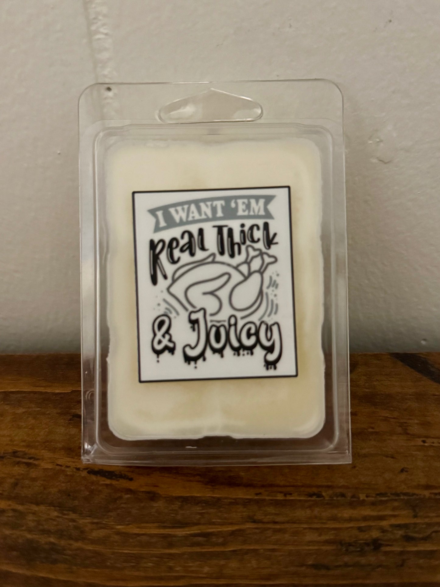 Packaged product with text 'I Want 'Em Real Thick & Juicy' on a wooden surface.