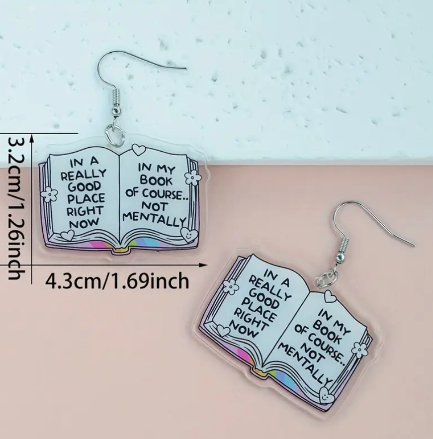 Acrylic dangle earrings shaped like open books—one page reads In a Really Good Place Right Now, the other In My Book of Course… Not Mentally, with stainless steel hooks.