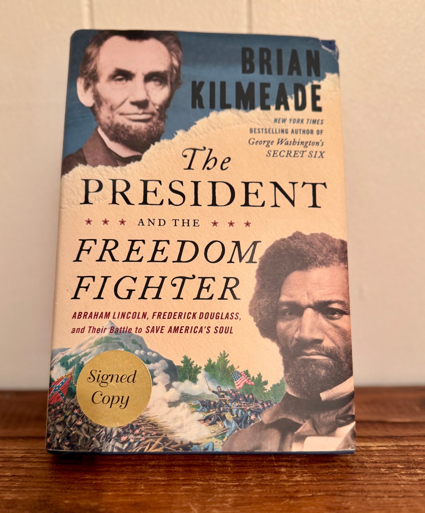 Book cover of 'The President and the Freedom Fighter' by Brian Kilmeade on a wooden surface.