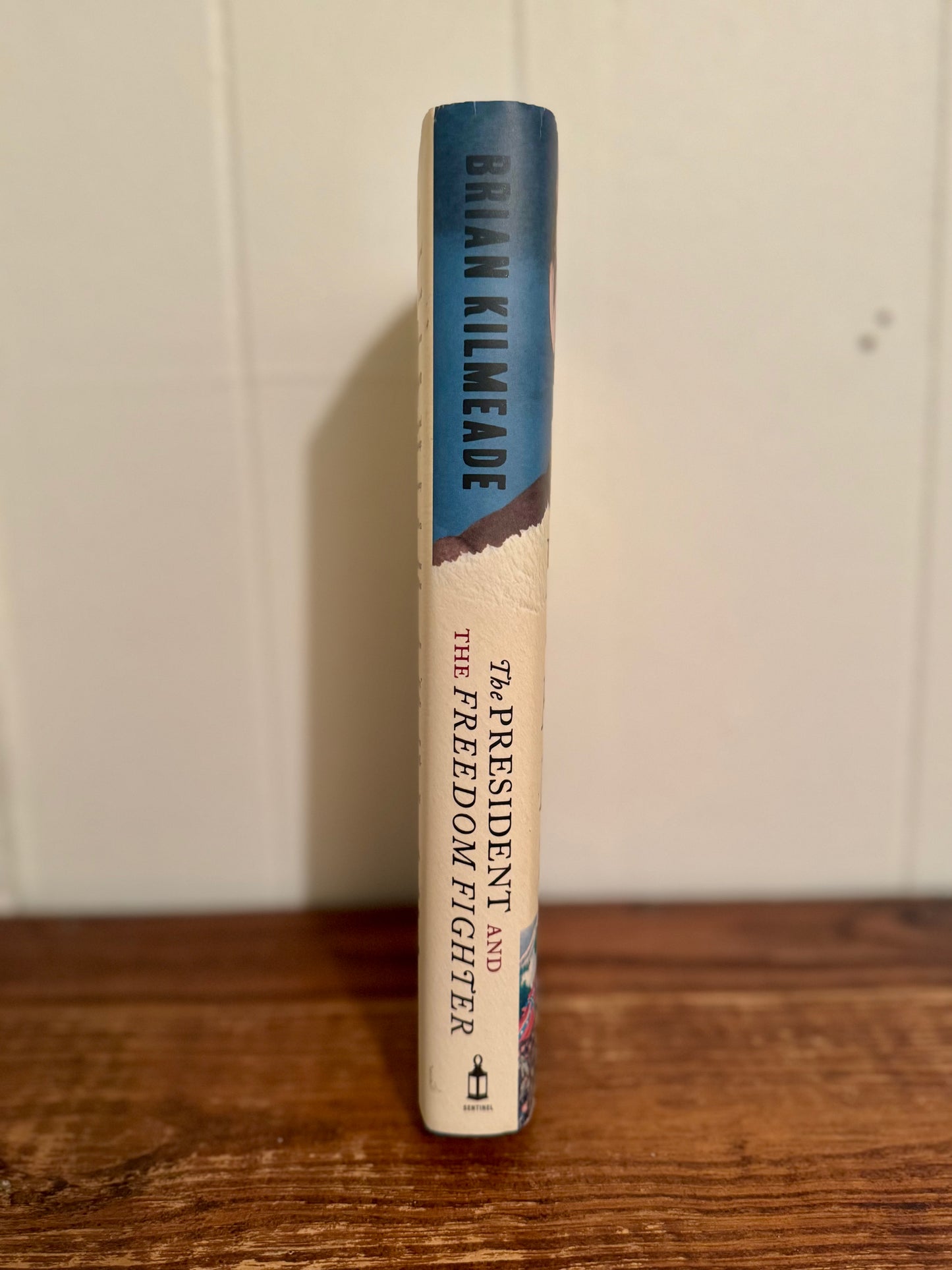 Book titled 'The President and the Freedom Fighter' by Brian Kilmeade on a wooden surface with a white background