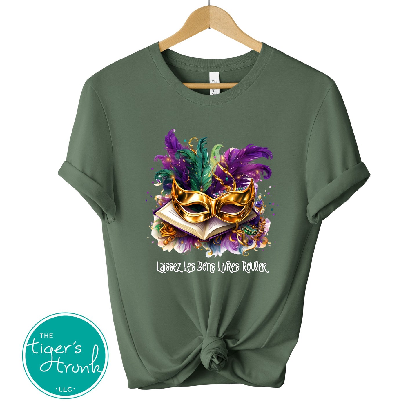 Green t-shirt with a Mardi Gras mask design on a hanger, featuring the Tiger's Trunk logo.
