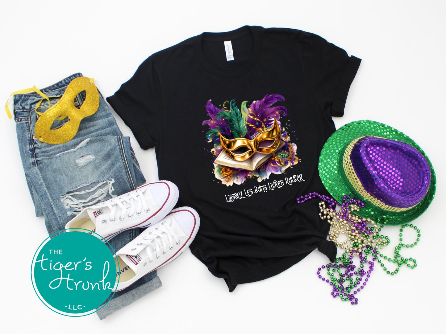 Black t-shirt with Mardi Gras design, jeans, sneakers, and festive accessories on a white background.