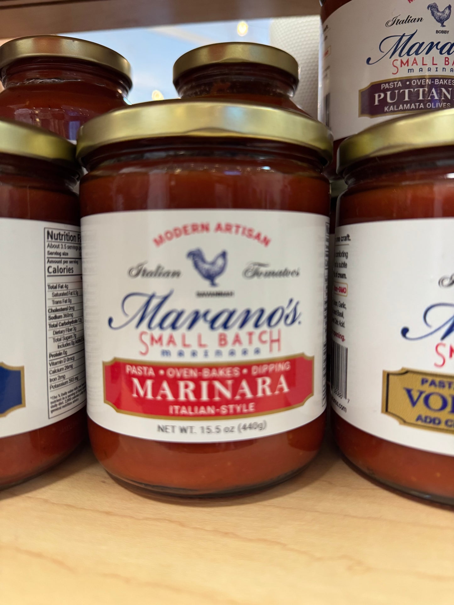 Jars of Marano's Small Batch Marinara sauce on a wooden surface