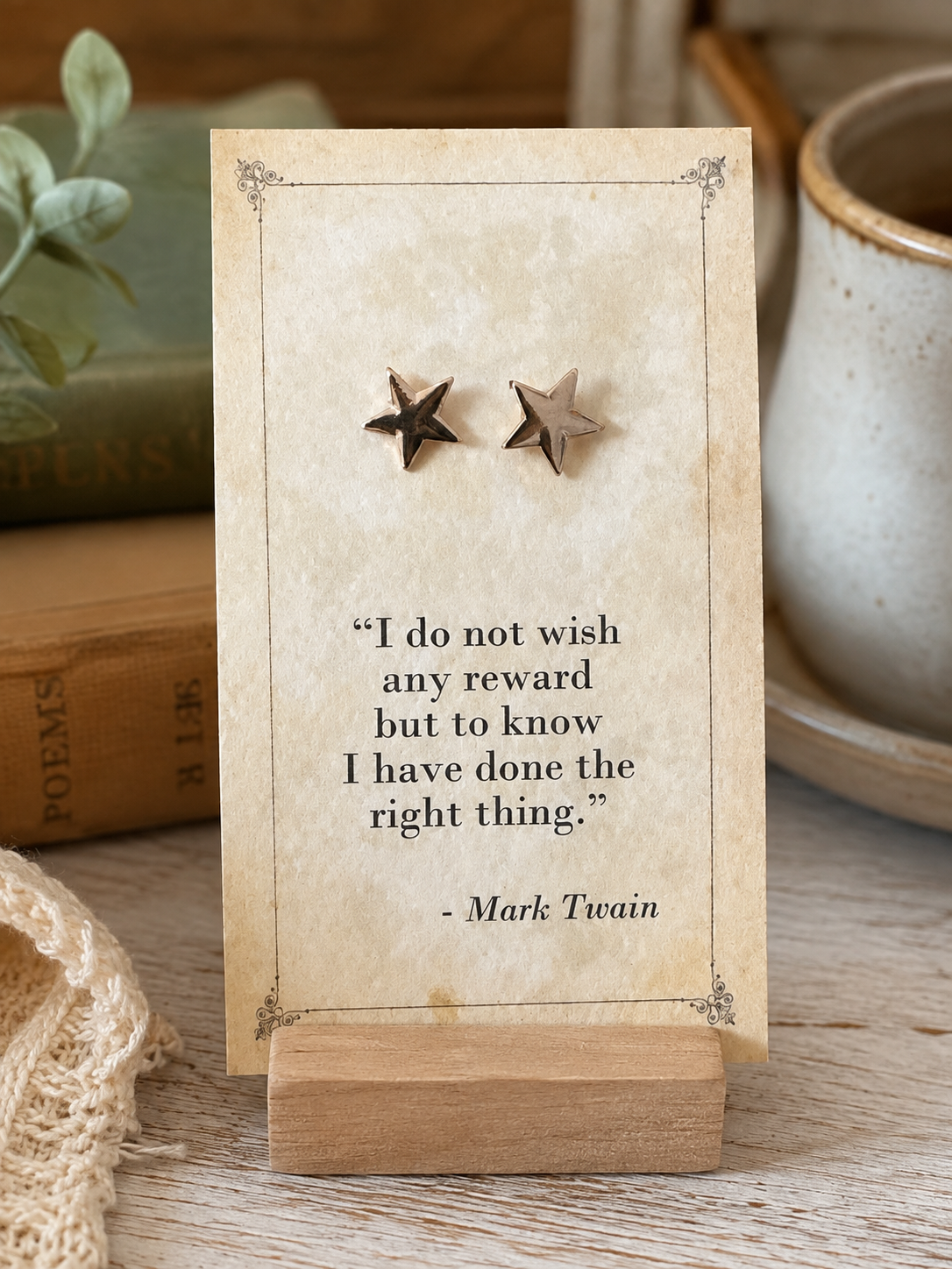 Small gold tone star stud earrings displayed on a vintage Mark Twain literary quote card