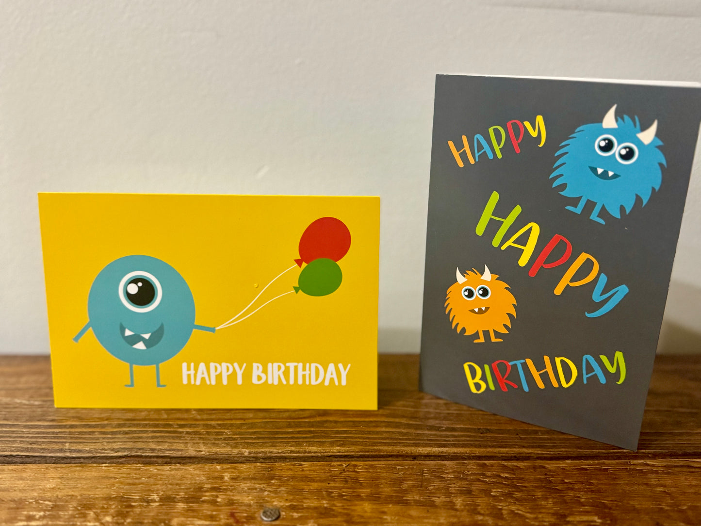 A fun and colorful set of three monster-themed birthday cards for kids, featuring one gray design and two yellow designs.