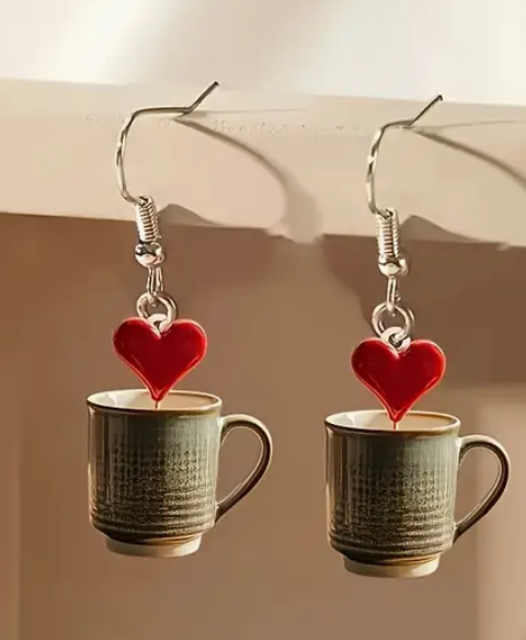 Acrylic earrings shaped like coffee mugs with heart-shaped foam art on top, perfect for coffee lovers and cozy accessory fans.