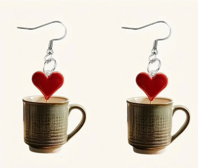 Acrylic earrings shaped like coffee mugs with heart-shaped foam art on top, perfect for coffee lovers and cozy accessory fans.