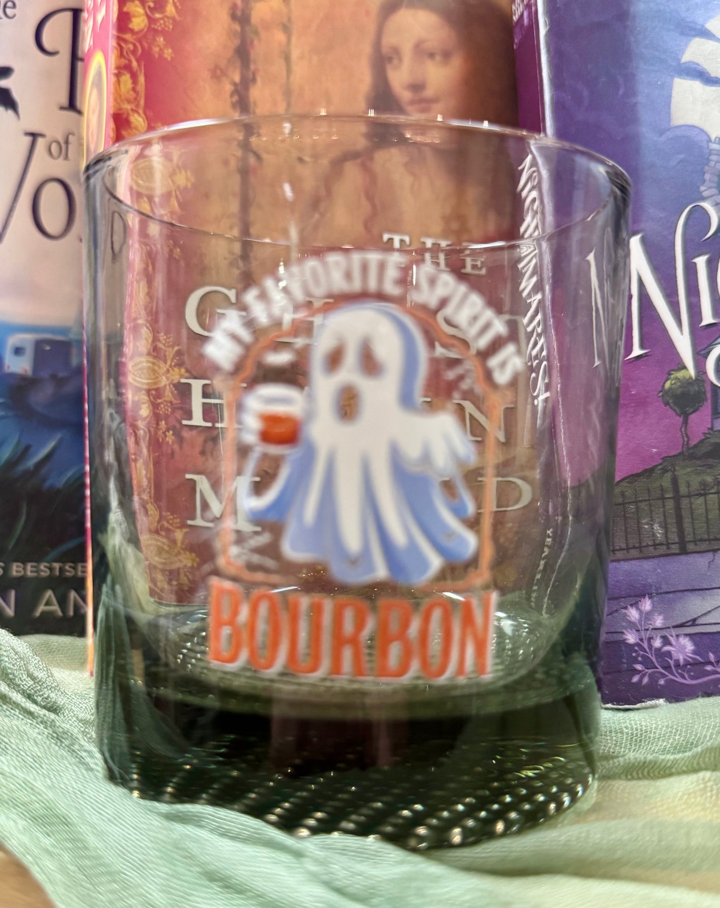 Glass with a ghostly label in front of books