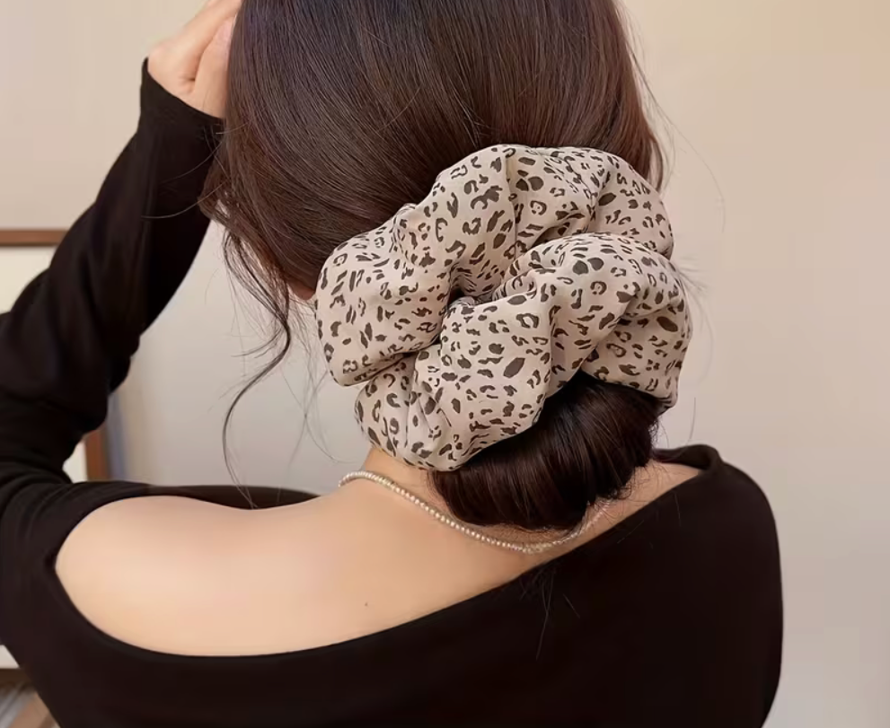 Oversized neutral leopard print scrunchie worn around a low bun