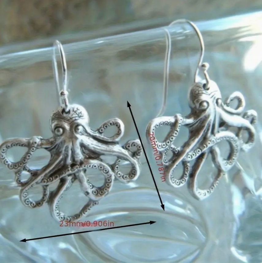 Silver octopus earrings with measurements on a clear background