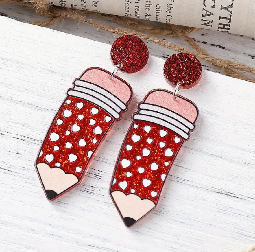 Pair of red acrylic pencil earrings featuring white heart accents, perfect for teachers and school-themed outfits.