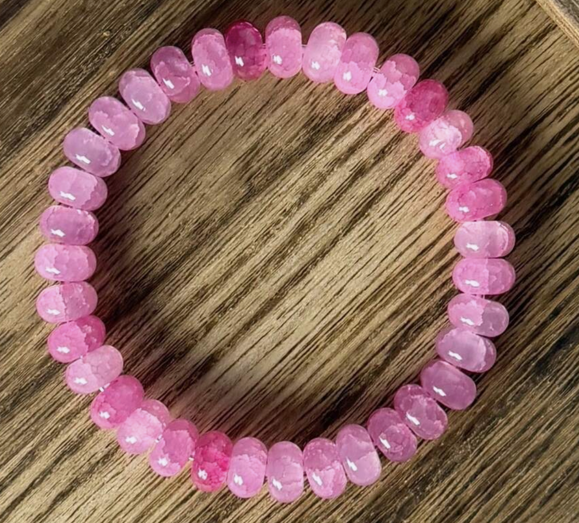 Pink beaded bracelet on a wooden surface