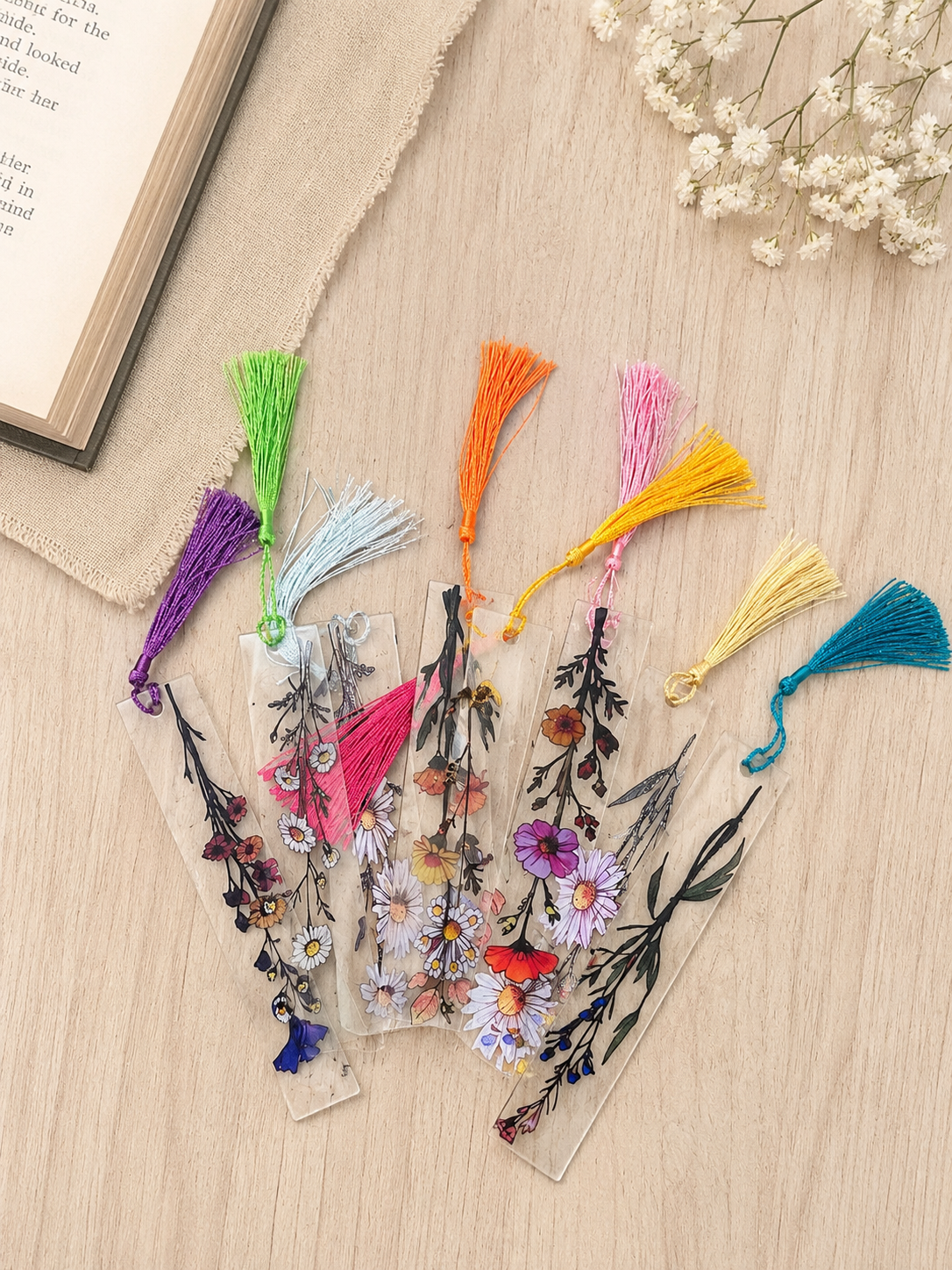 Assorted clear acrylic bookmarks with colorful pressed flower designs and coordinating tassels, sold individually