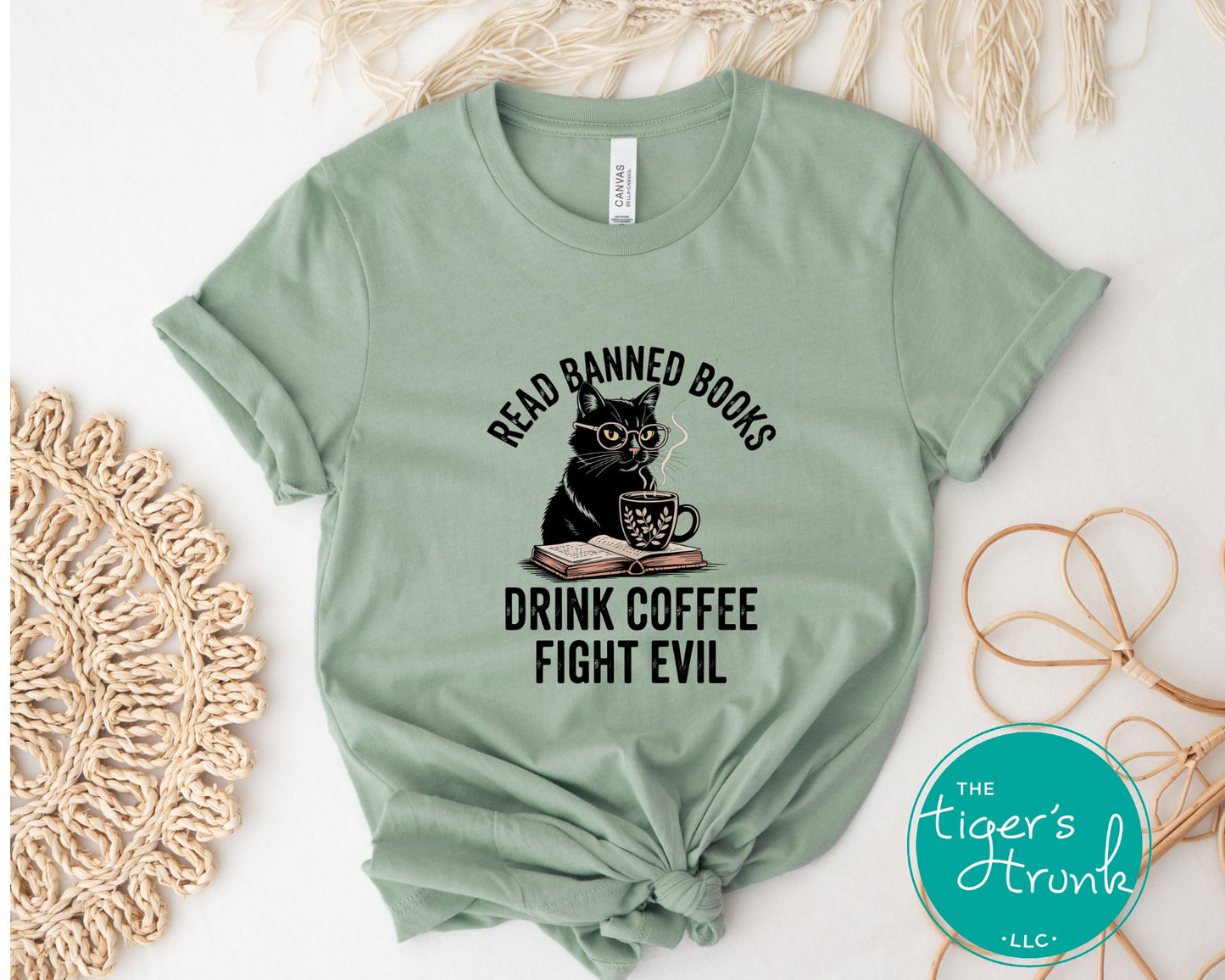 Green t-shirt with a cat graphic and text on a white surface with decorative elements.