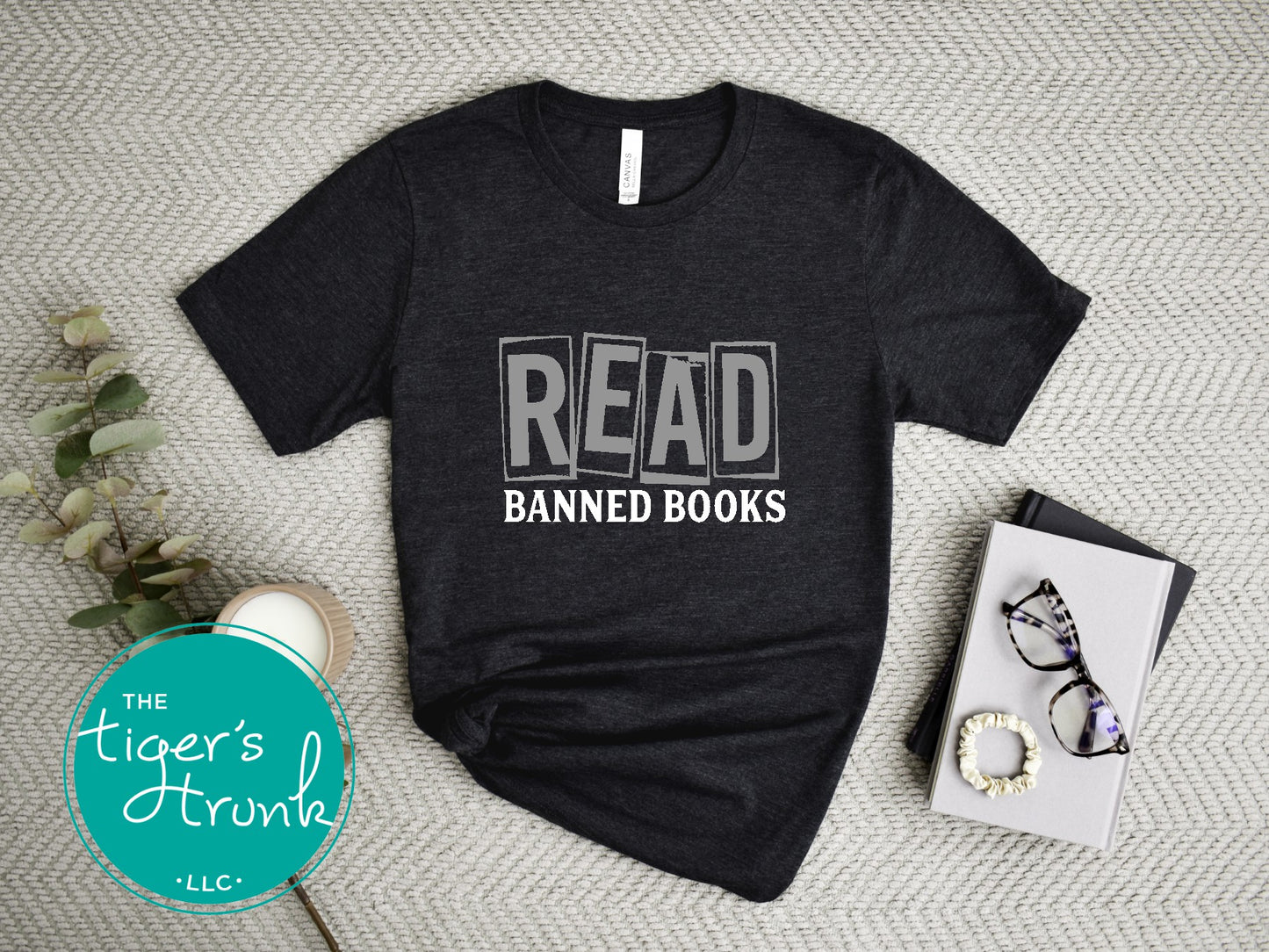 Black t-shirt with 'READ BANNED BOOKS' text on a textured surface with decorative items.