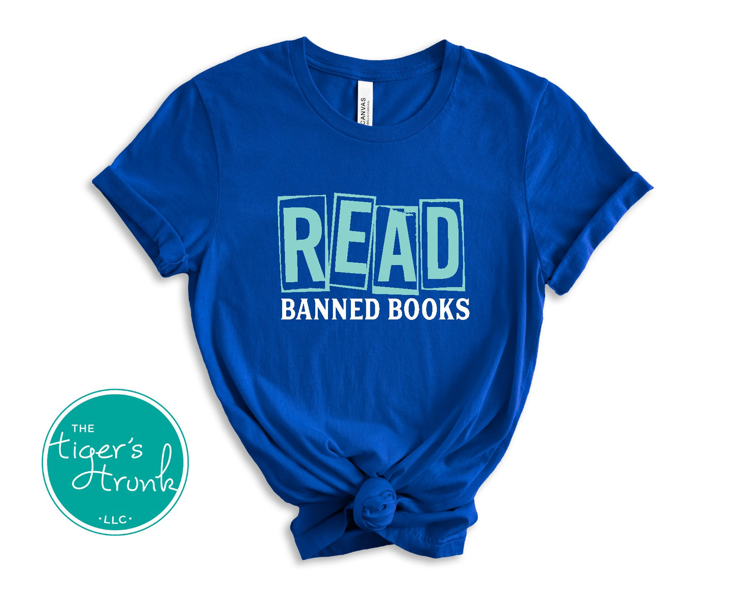 Blue t-shirt with 'READ BANNED BOOKS' text on a white background, featuring The Tiger's Den logo.