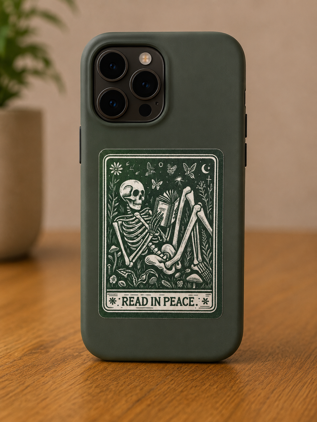 Vintage-style Read in Peace vinyl sticker featuring a skeleton reading a book surrounded by flowers, butterflies, and woodland details.