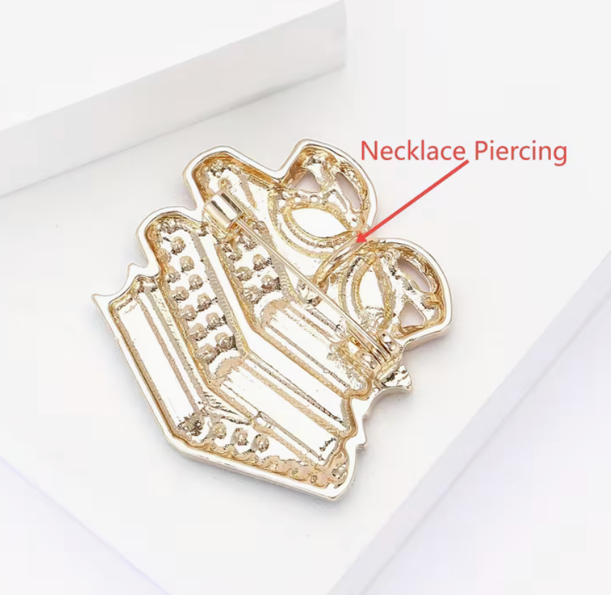 A silver-toned necklace piercing stud shaped like a crown, shown on a white background with a red text overlay pointing to it.