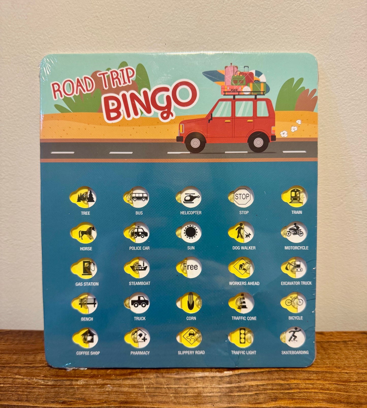 Road trip bingo card featuring colorful icons like stop signs, cows, and airplanes—ideal for kids during long car rides.