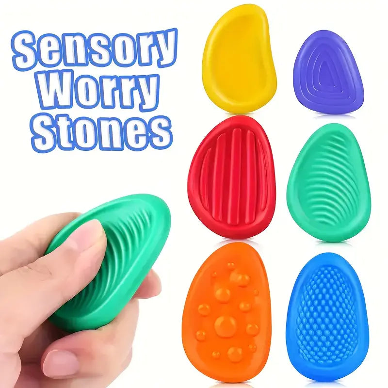 Smooth, stone-shaped sensory fidget toys in assorted calming colors, designed for stress relief, grounding, and tactile focus.