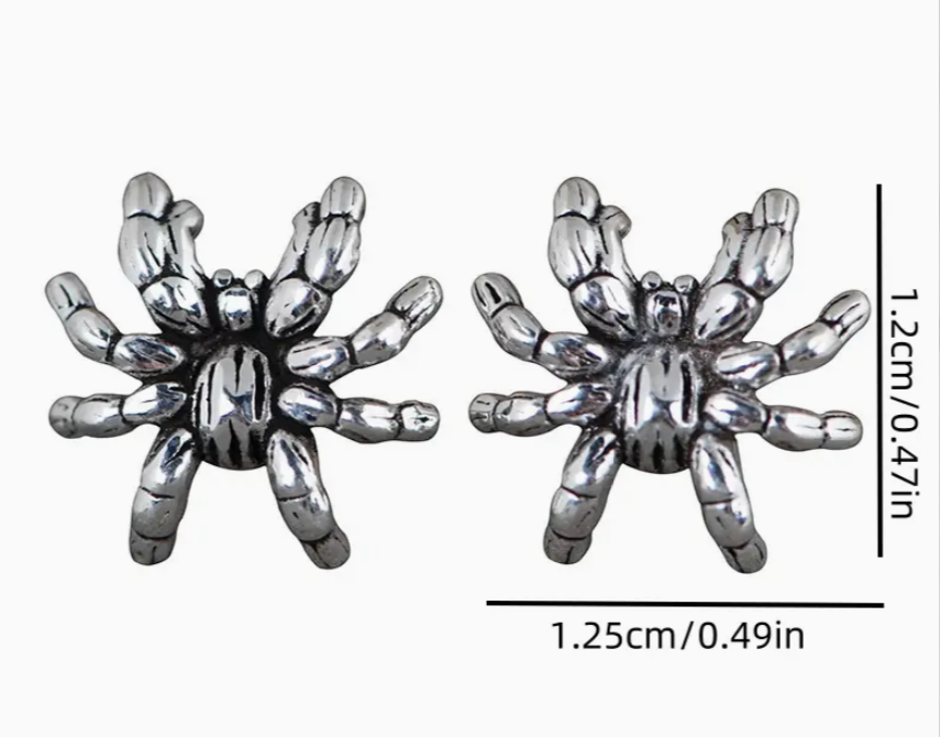 Pair of silver spider web earrings with measurements on a white background
