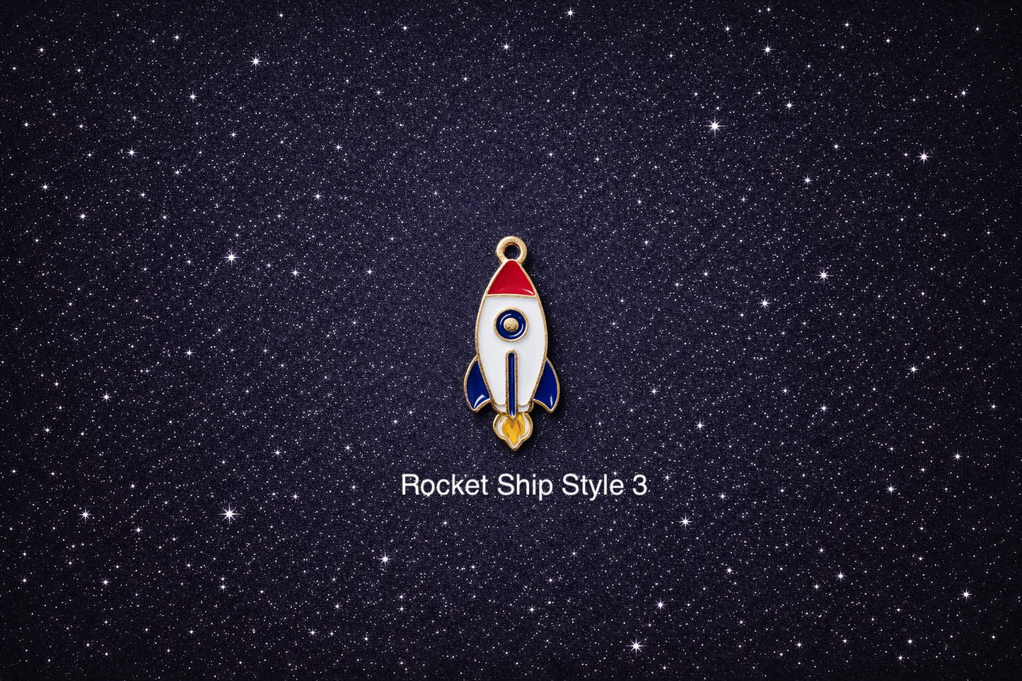 White, blue, and red enamel rocket charm with gold outline on a dark starry background, sold individually for bracelets, necklaces, and keychains.