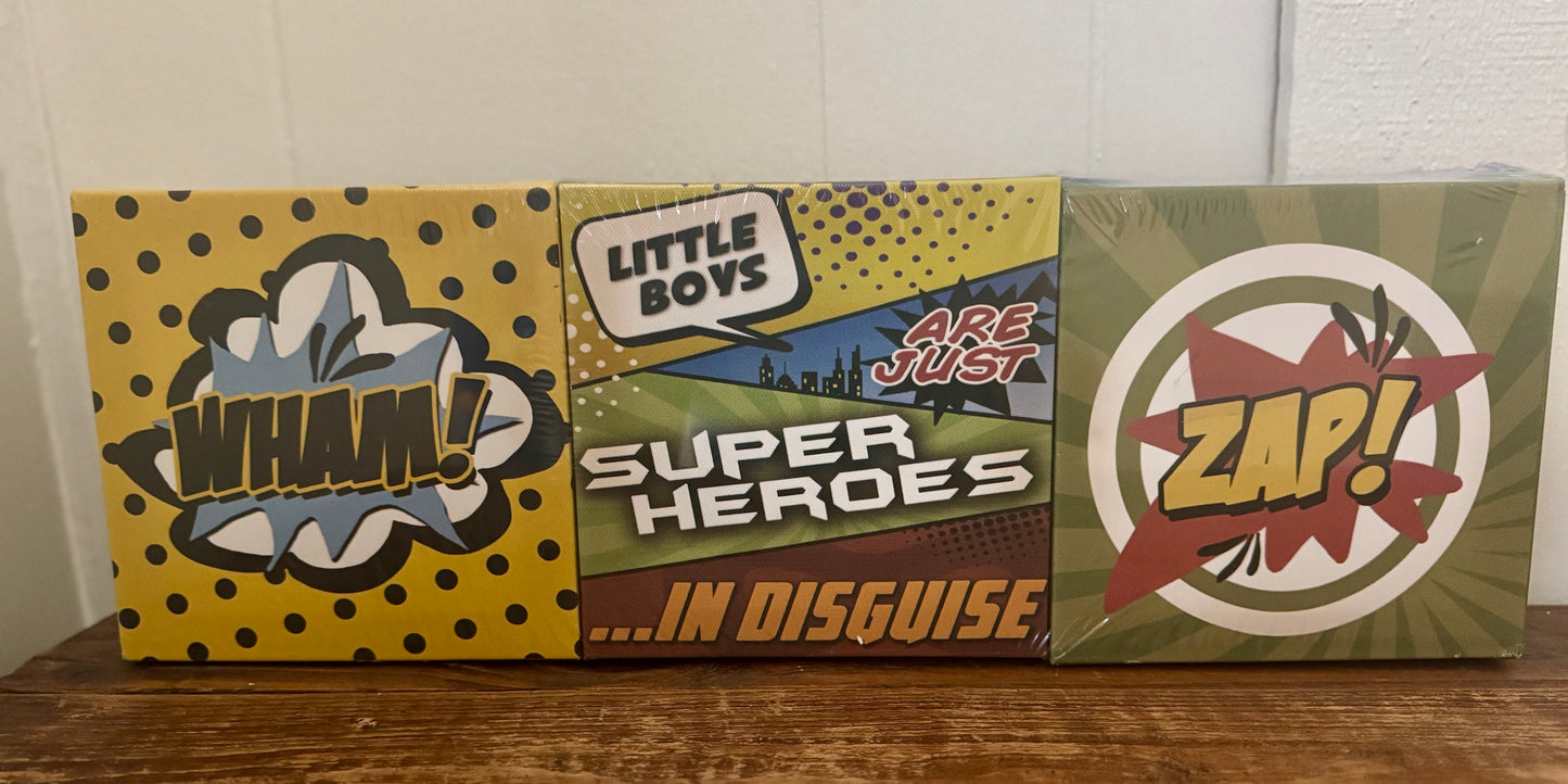 Set of 6 superhero-themed square canvases with phrases like BOOM, ZAP, WHAM, and SUIT UP in comic book style