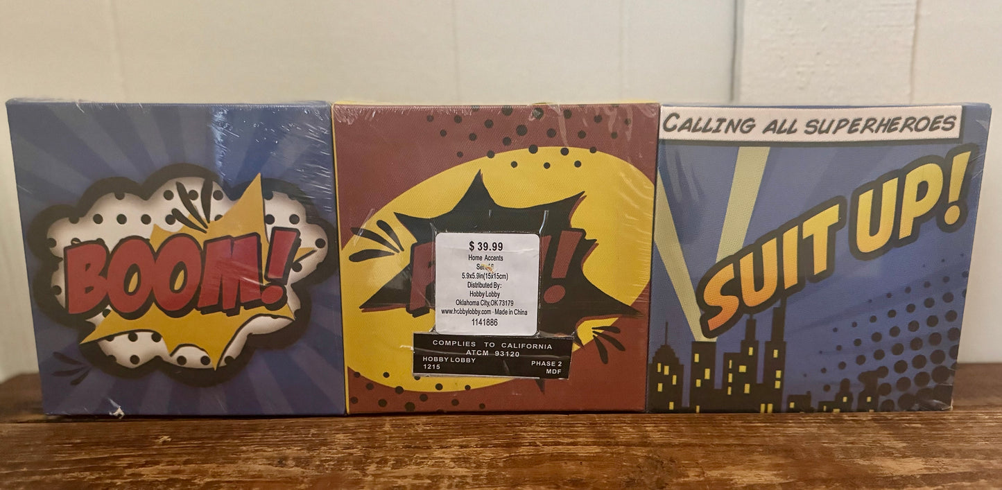 Set of 6 superhero-themed square canvases with phrases like BOOM, ZAP, WHAM, and SUIT UP in comic book style