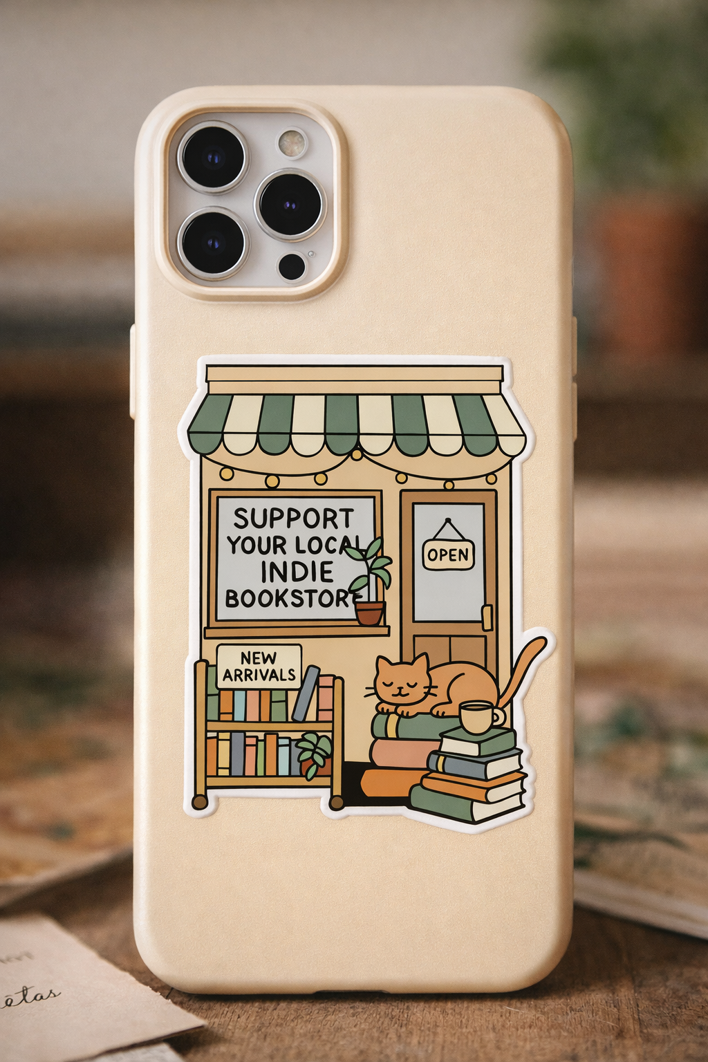Support your local indie bookstore sticker with cozy bookstore illustration, books, and sleeping cat on phone case