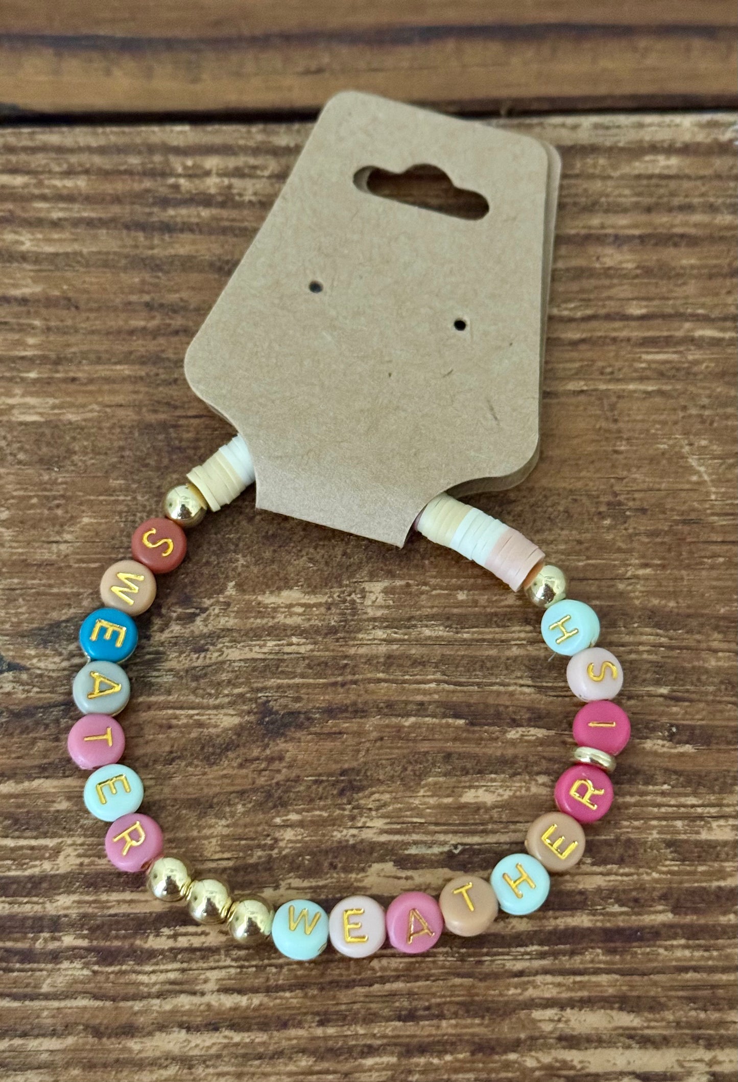 Beaded bracelet with colorful letters on a wooden surface