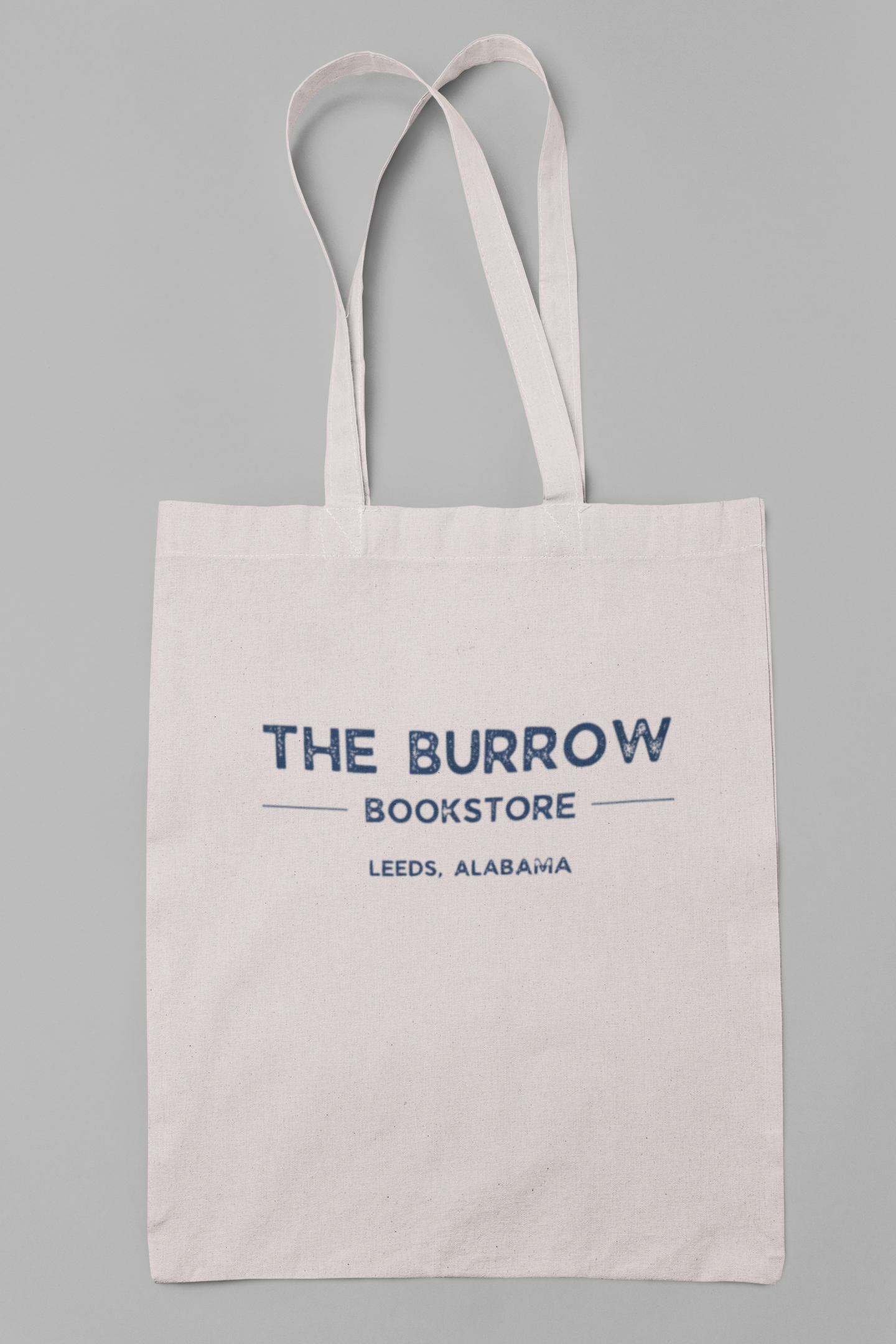 Canvas tote bags featuring The Burrow Bookstore logo on one side and various literary quotes on the other side.