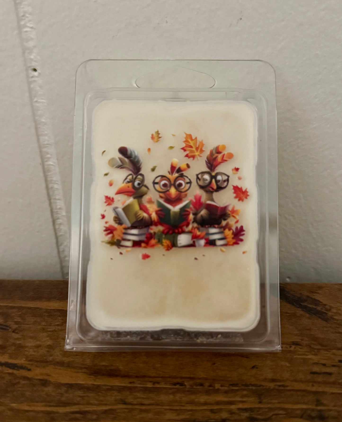 Candle melt wax block with owl design in clear packaging on a wooden surface.