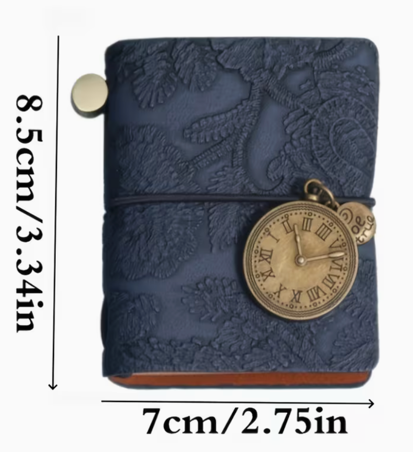 A navy blue embossed leather journal or planner cover with a vintage-style pocket watch charm, shown on a white background with dimension labels indicating 8.5 cm height and 7 cm width.