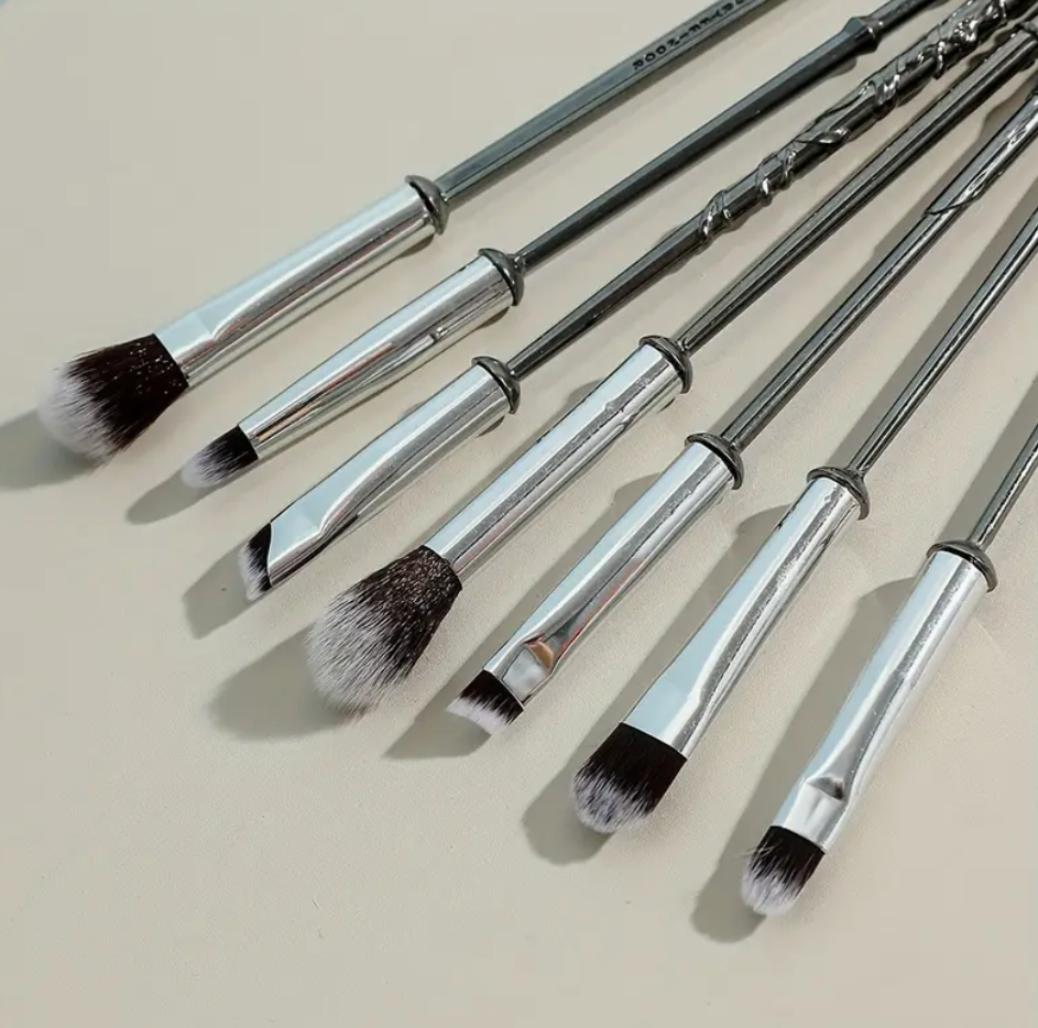 Set of makeup brushes with handles designed to resemble wizard wands, featuring intricate detailing and soft bristles.