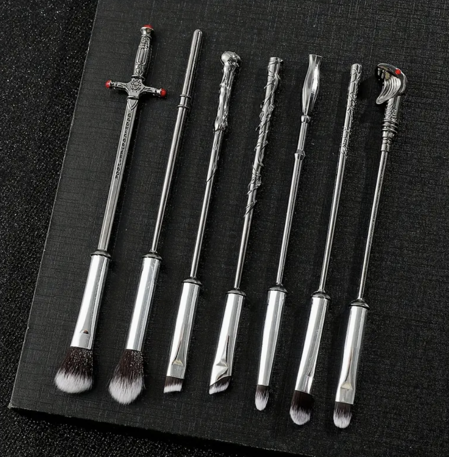 Set of makeup brushes with handles designed to resemble wizard wands, featuring intricate detailing and soft bristles.