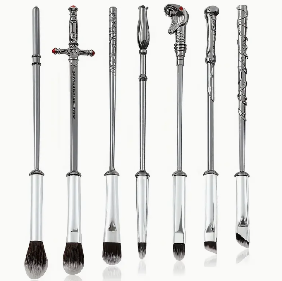 Set of makeup brushes with handles designed to resemble wizard wands, featuring intricate detailing and soft bristles.