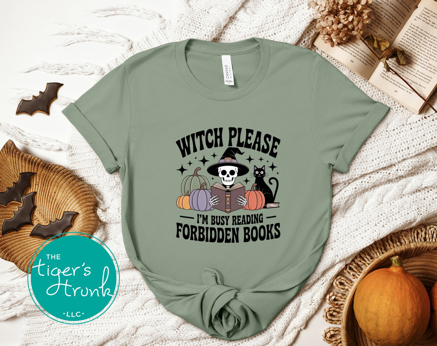 Green t-shirt with Halloween-themed design on a textured surface with pumpkins and cookies.