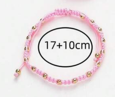 Pink beaded bracelet with gold accents on a white background