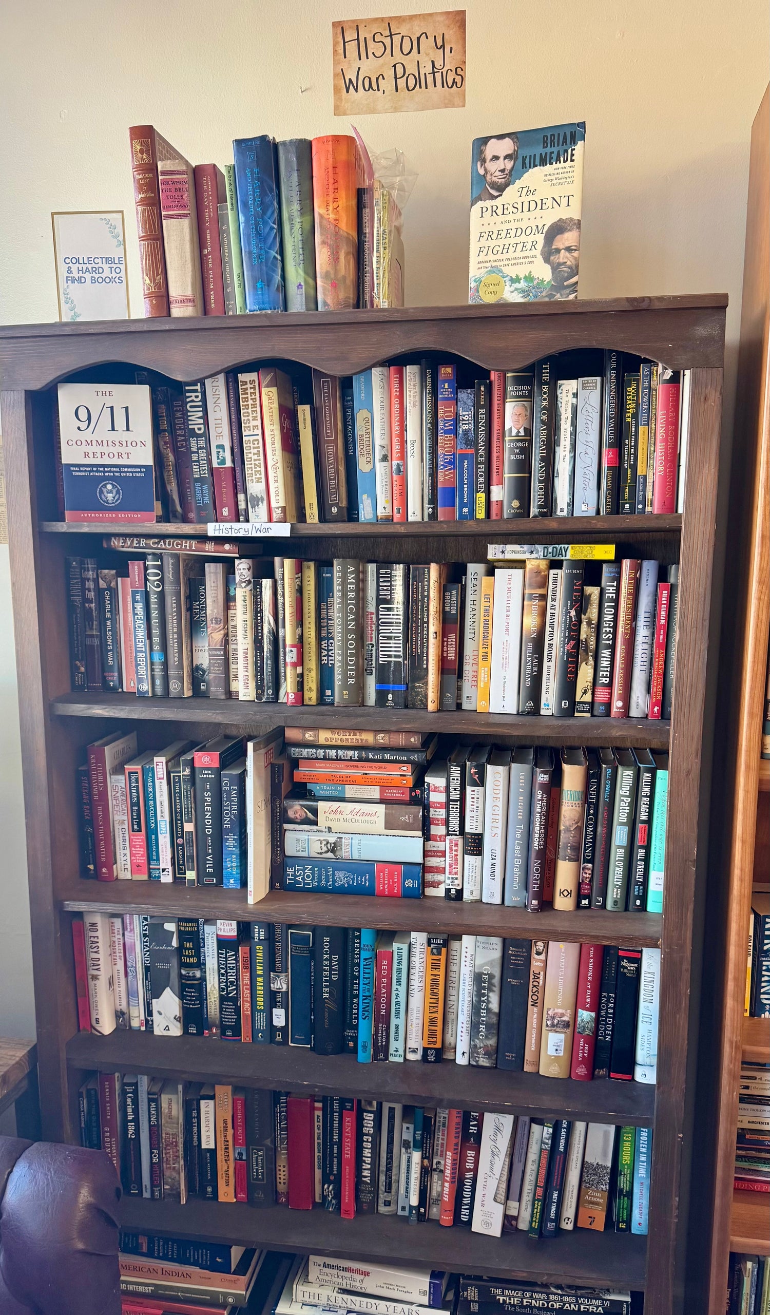 A thoughtful bookstore display featuring war and conflict nonfiction books arranged beside a small globe, vintage-style memorabilia, and soft, respectful lighting.