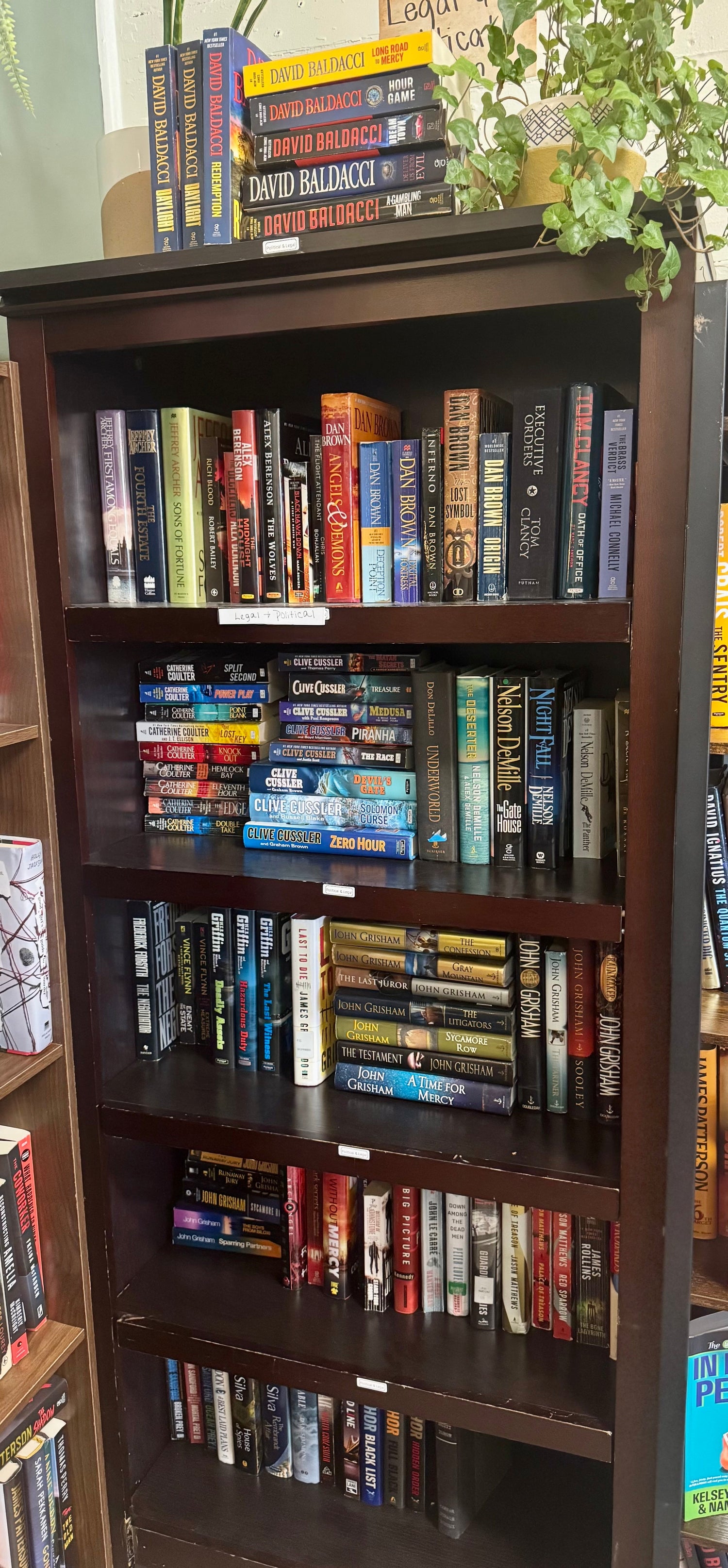 A sophisticated bookstore display featuring political and legal mystery novels, a gavel, reading glasses, and moody lighting to convey tension and intrigue.