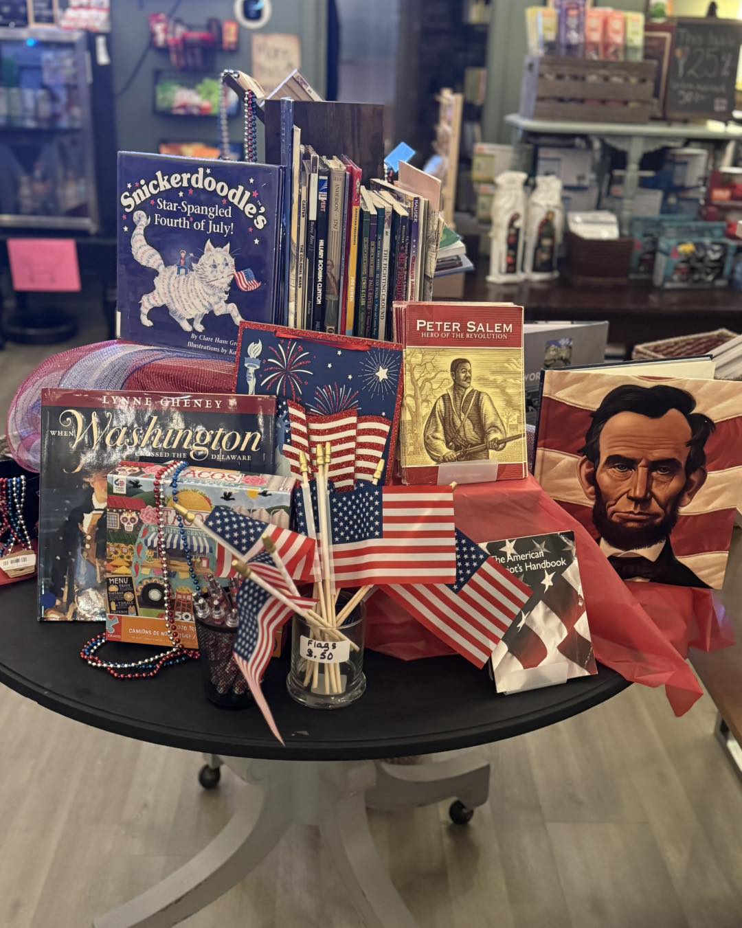 A festive display featuring patriotic children’s books and red-white-and-blue décor arranged in a bright, cheerful bookstore setting.