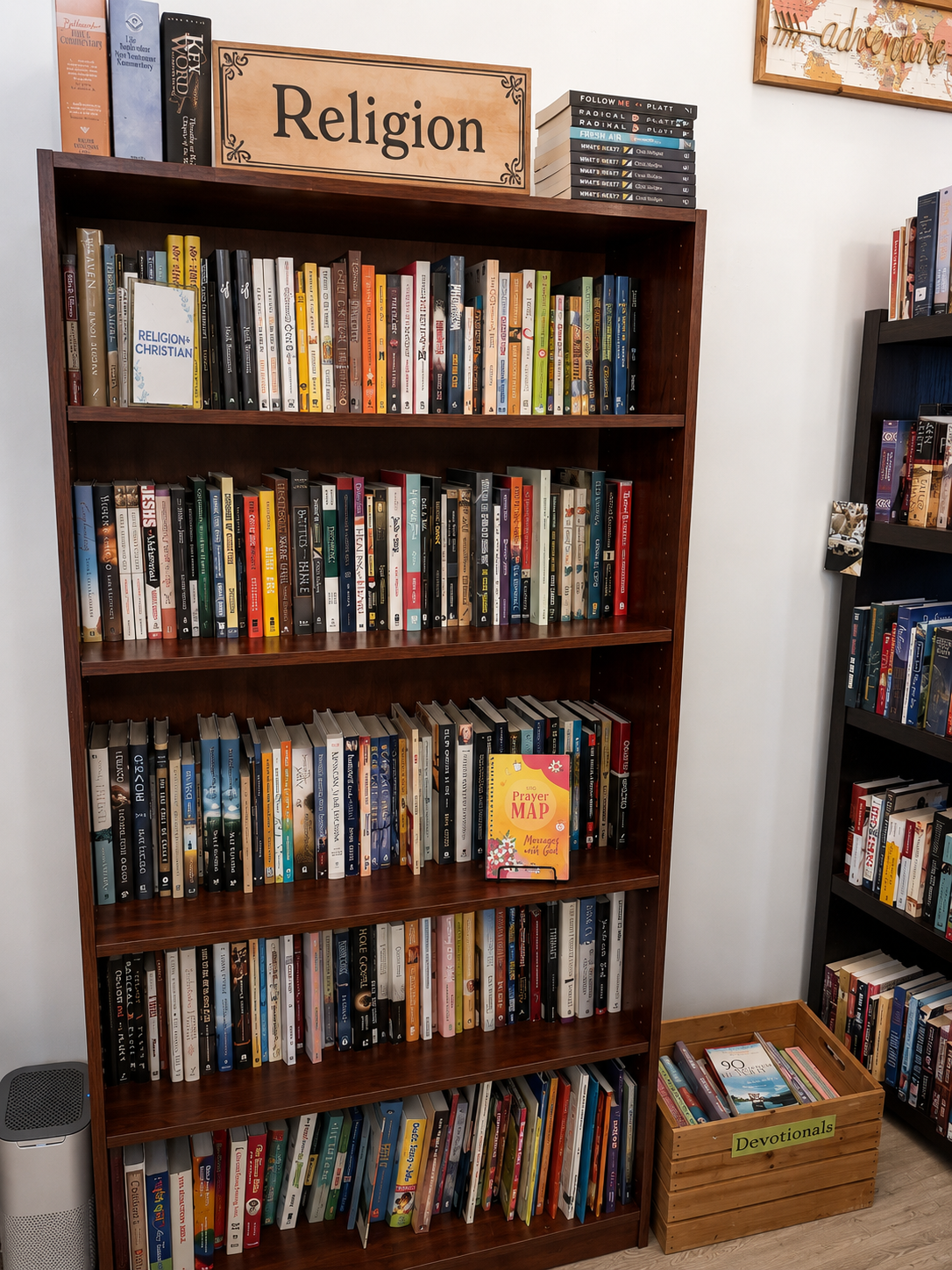 A peaceful bookstore display featuring religion and spirituality nonfiction books arranged beside a small candle, a plant, and warm natural lighting for a calming, reflective feel.
