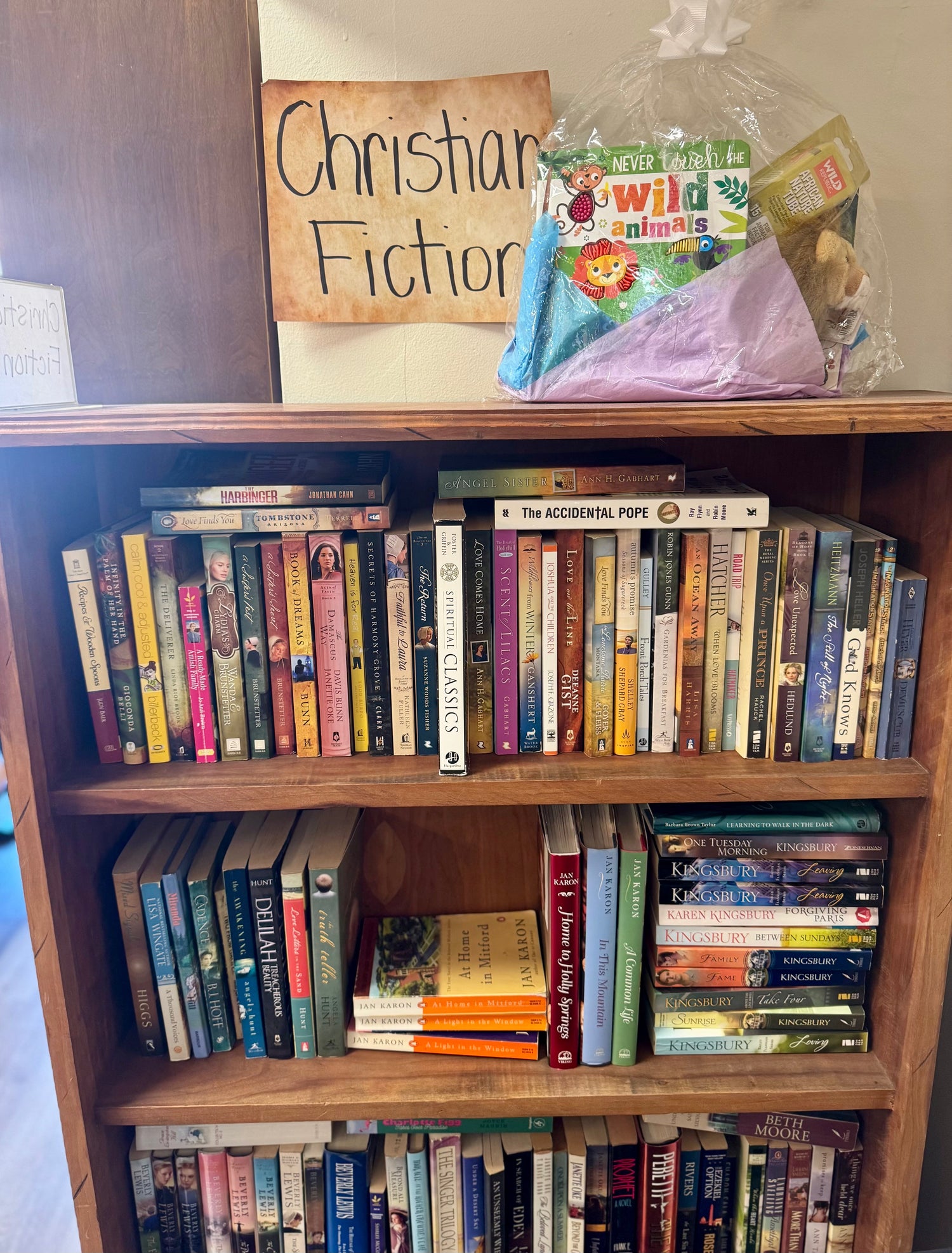 A peaceful bookstore display featuring faith-based and spiritual fiction books, a candle, a small plant, and soft, natural lighting creating a calm, reflective atmosphere.