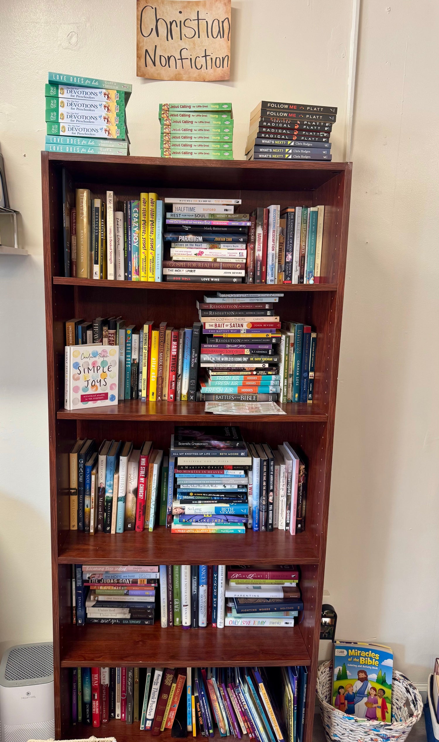 A peaceful bookstore display featuring religion and spirituality nonfiction books arranged beside a small candle, a plant, and warm natural lighting for a calming, reflective feel.