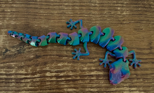 Colorful gecko-shaped object on a wooden surface